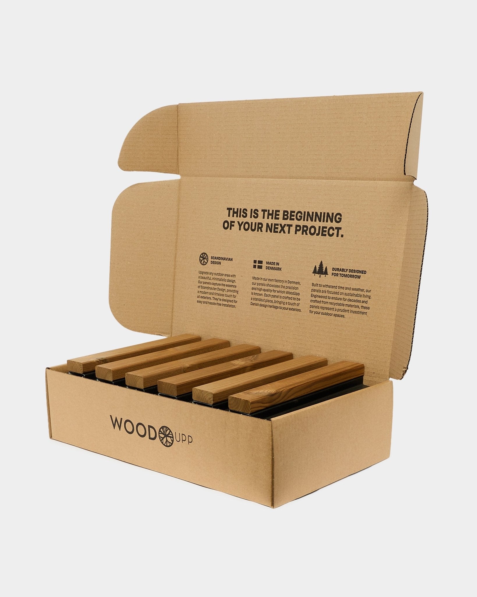 Open cardboard box labeled WoodUpp with Aluwood Complete Sample Set and detailed product information printed on the inside of the lid.